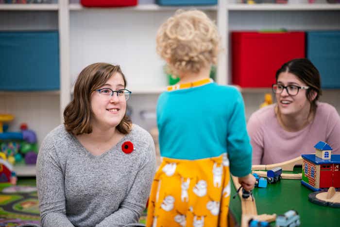 Two Early Childhood Educators interact with a toddler