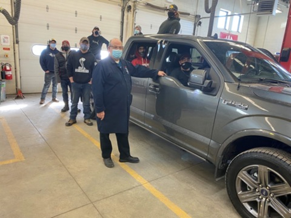 Instructor Denis Lalonde and Automotive Tech students stand beside the 2020 F-150 Ford truck inside the SLC garage.