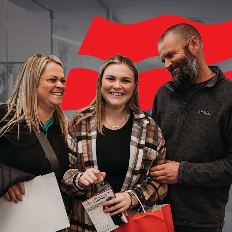 A student stands with her parents at Open House