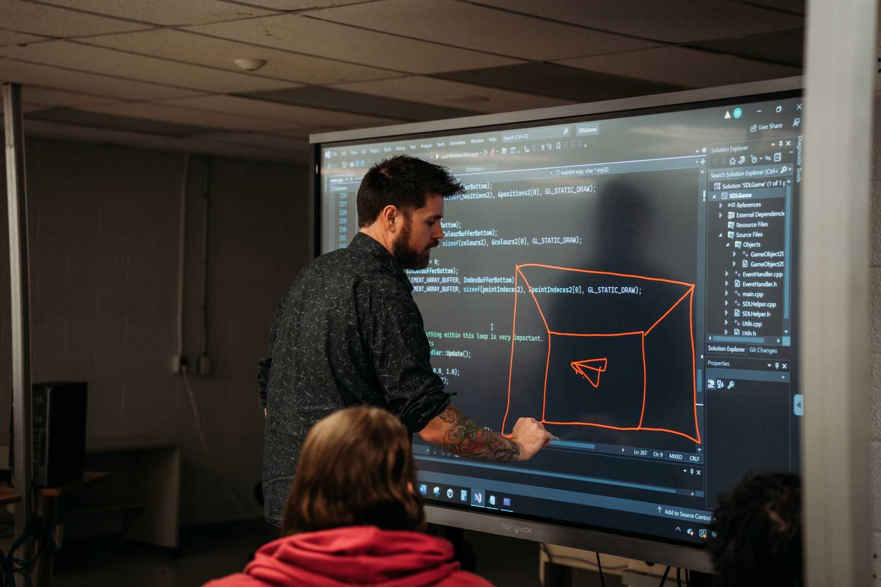 A professor works on a SMART board in the Game Programming classroom