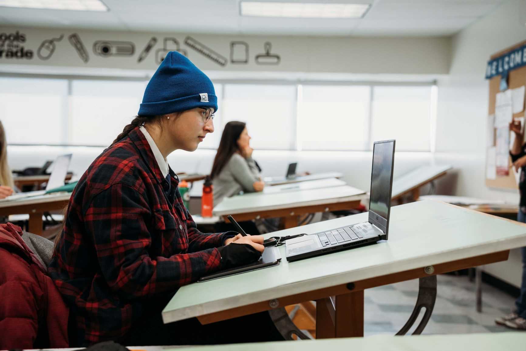 A student works on a laptop in the Graphic Design lab on Kingston campus