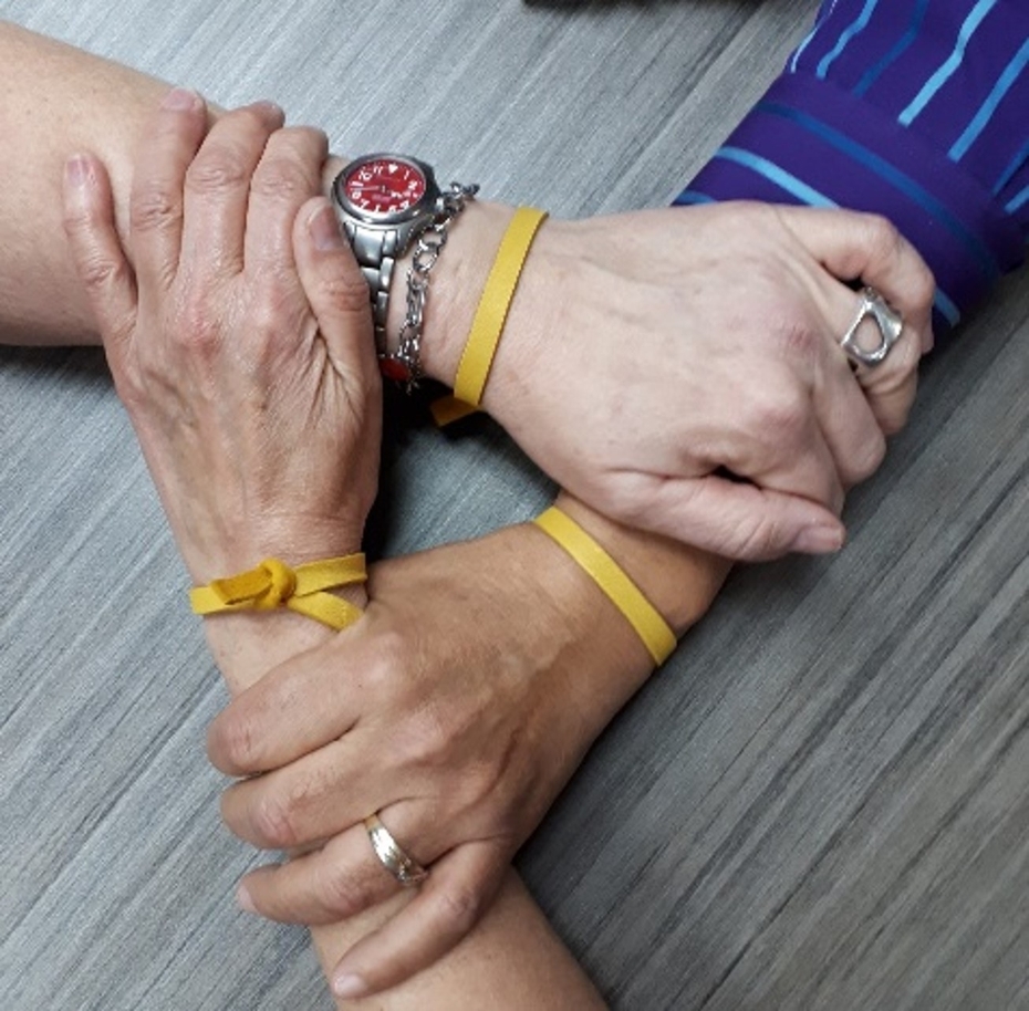 three hands hold each other to form a triangle