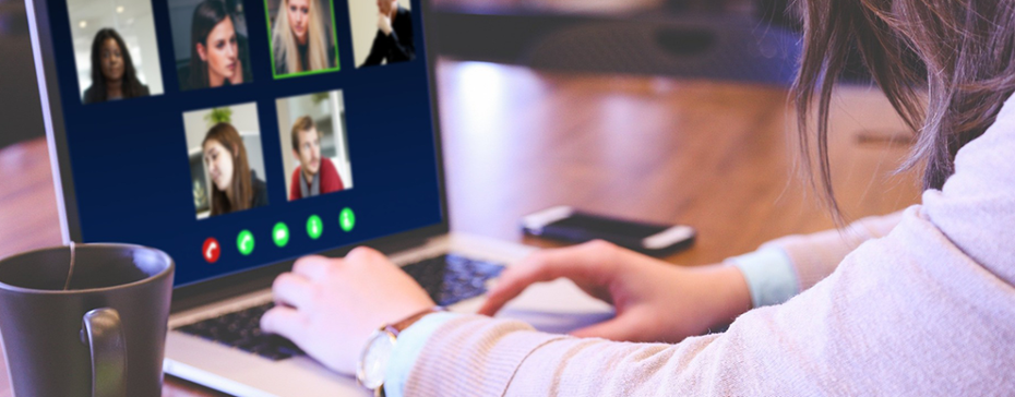 An individual sits in front of a laptop screen meeting with many colleagues virtually.